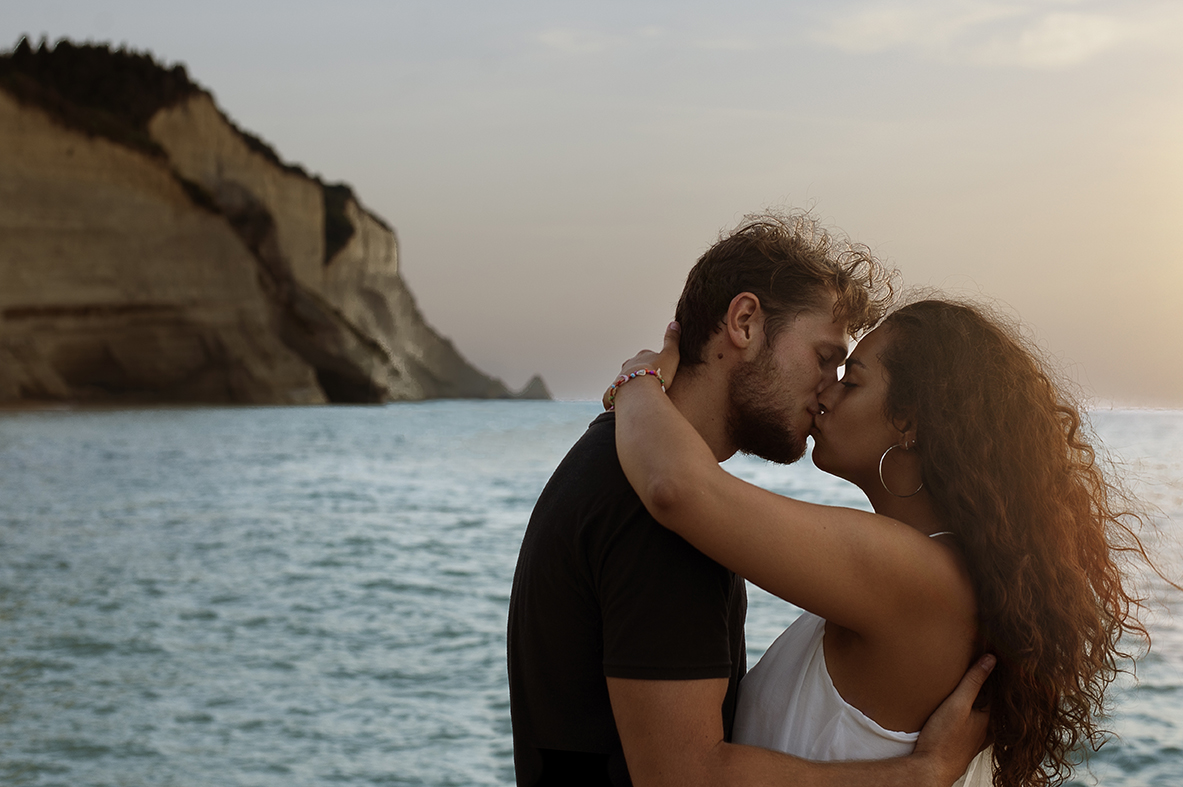 Greece Destination Engagement - Corfu - romantic kiss with blue sea background