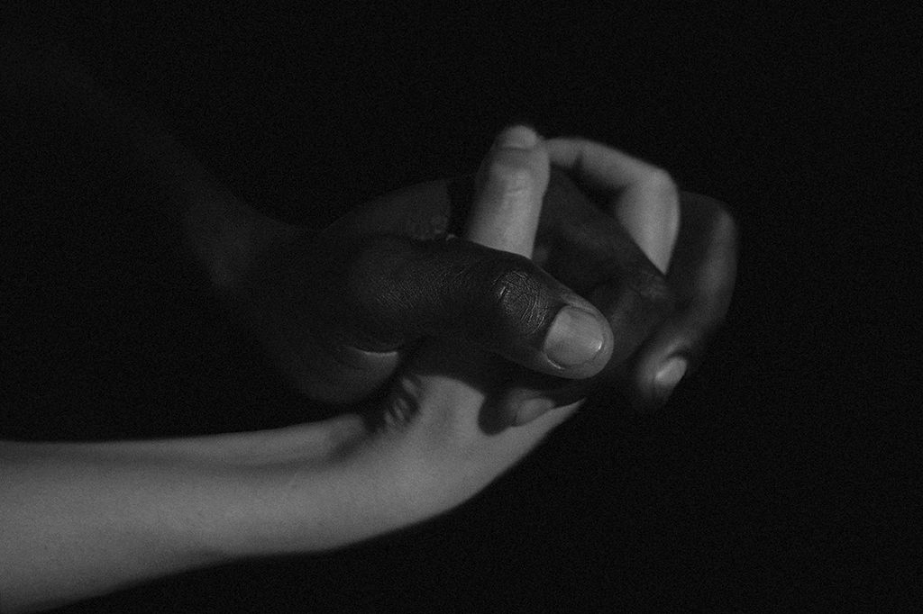 Interracial couple - detail - interlaced hands