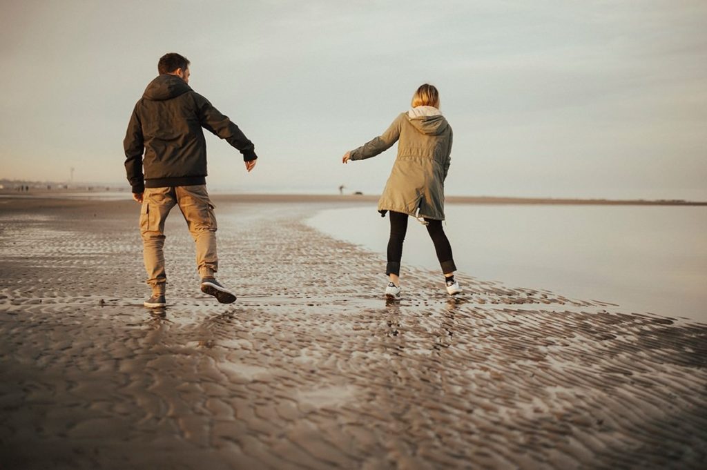 couple walking and dancing on the shore