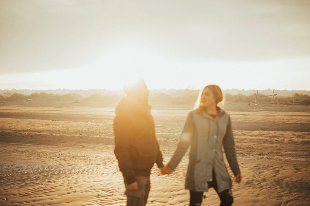 couple walking on a beach, blurred subjects